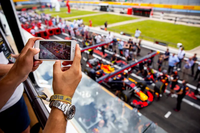 Spectator photographing an F1 pit lane