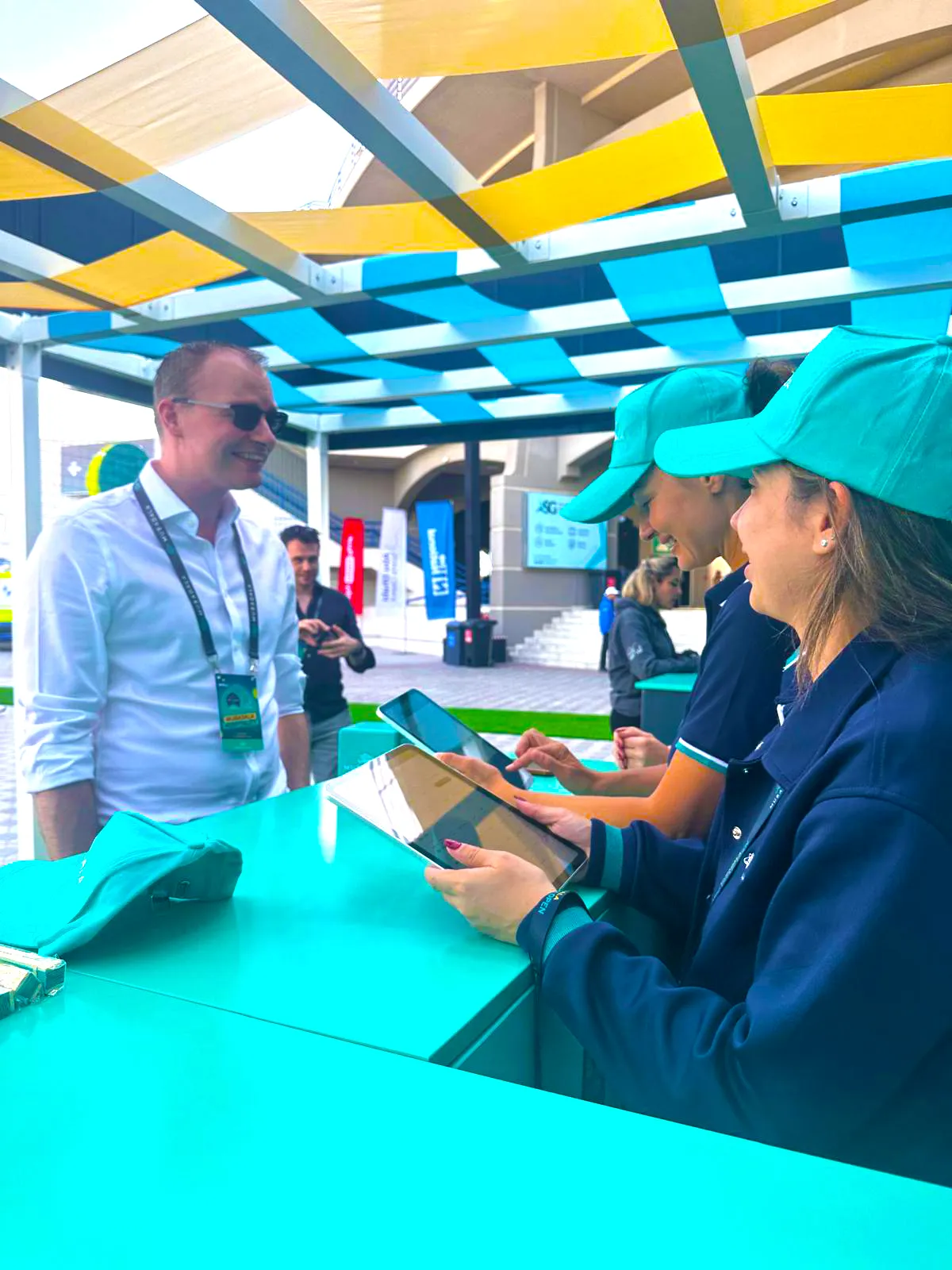 Event staff welcoming a guest at a Mubadala hospitality desk
